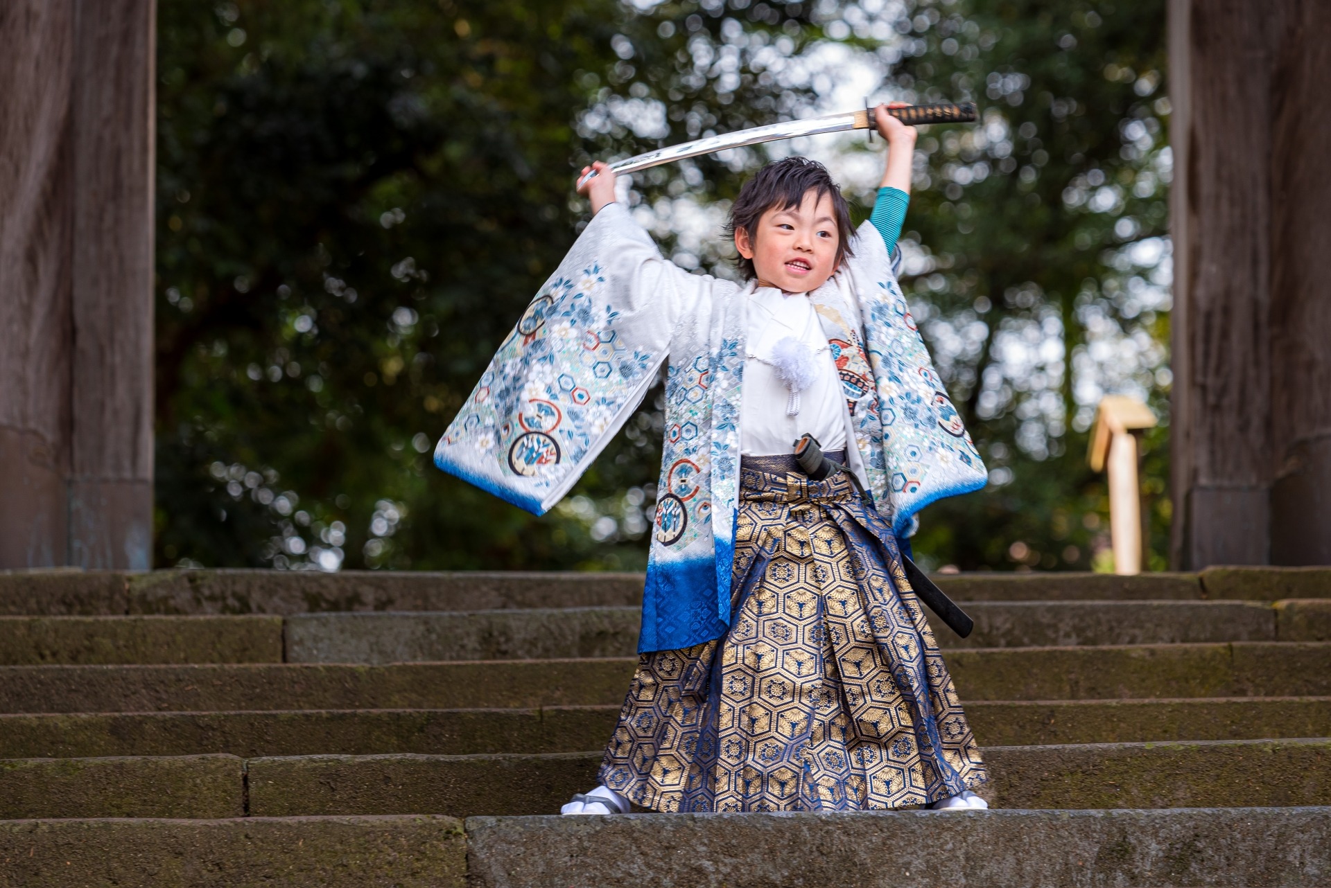 階段の上で刀を掲げる、七五三の袴姿の5歳の男の子