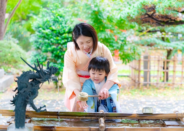 七五三の日に手水をする着物姿の母親と男の子